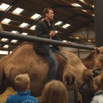 Frank Smits doet voor hoe je op een kameel gaat zitten